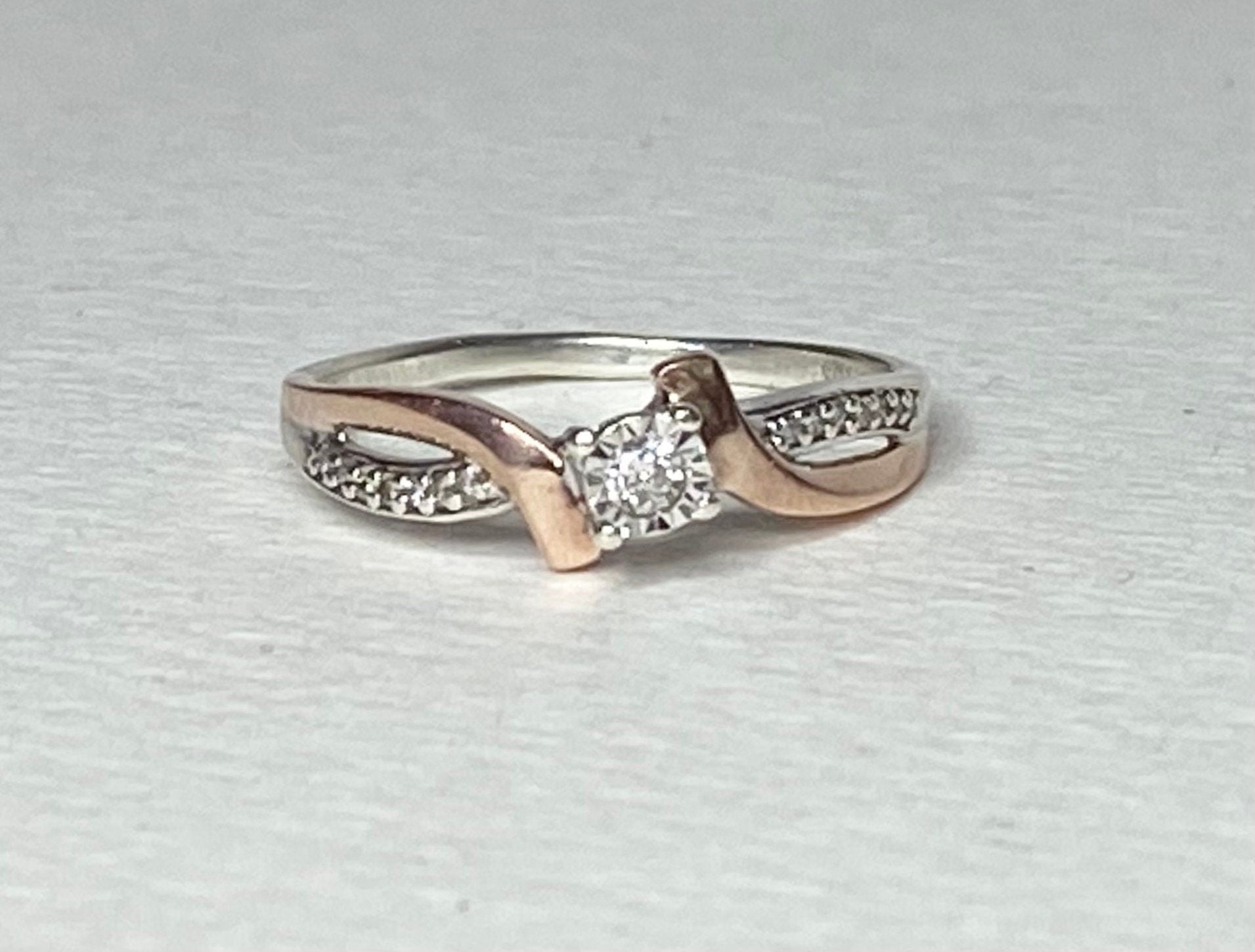 A size 7, 10k rose gold and sterling silver diamond band engagement ring.