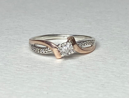 A size 7, 10k rose gold and sterling silver diamond band engagement ring.