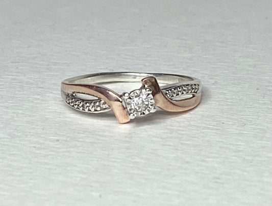 A size 7, 10k rose gold and sterling silver diamond band engagement ring.