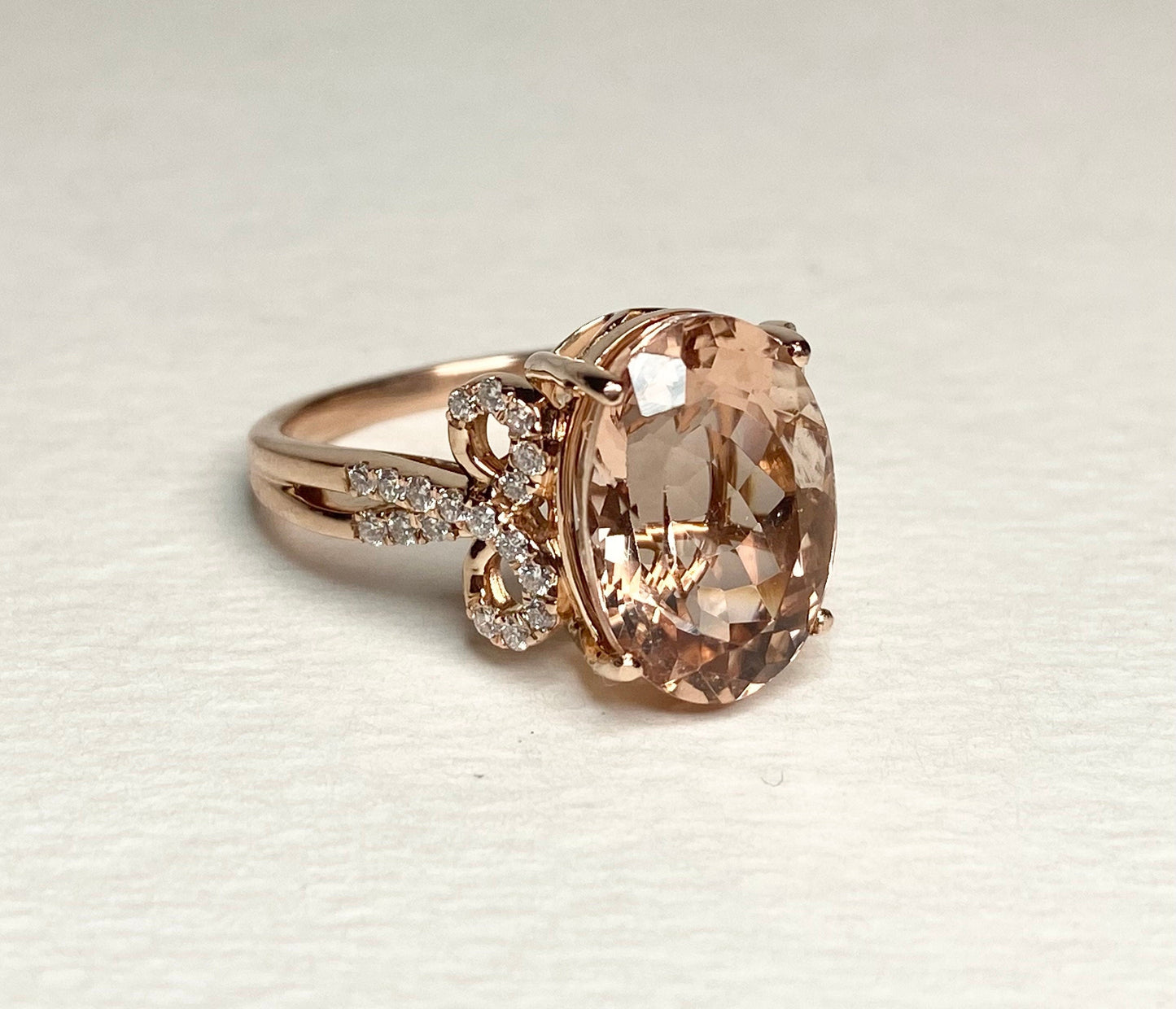 Solid 18k rose gold ring with oval morganite and diamond accents.