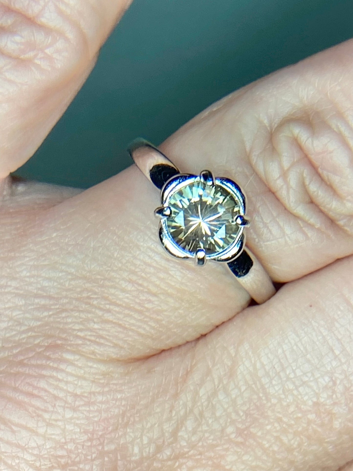 Sterling silver ring with a round, color-shifting Oregon Sunstone solitaire.