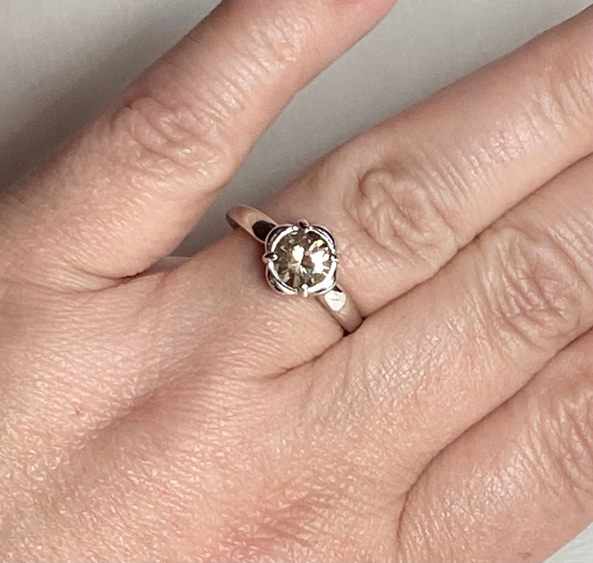 Sterling silver ring with a 1.18ct round Oregon Sunstone in a floral setting.