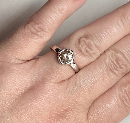 Sterling silver ring with a 1.18ct round Oregon Sunstone in a floral setting.