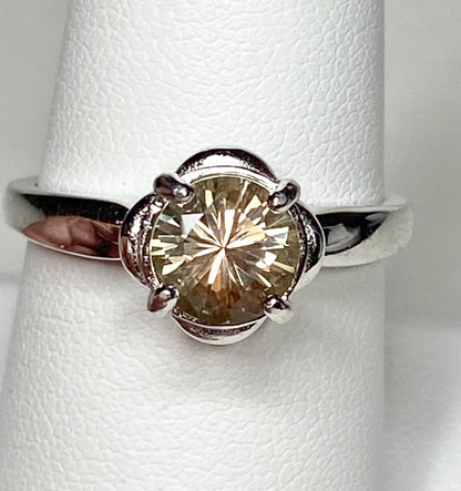 Sterling silver ring with a round, color-shifting Oregon Sunstone in a floral setting.