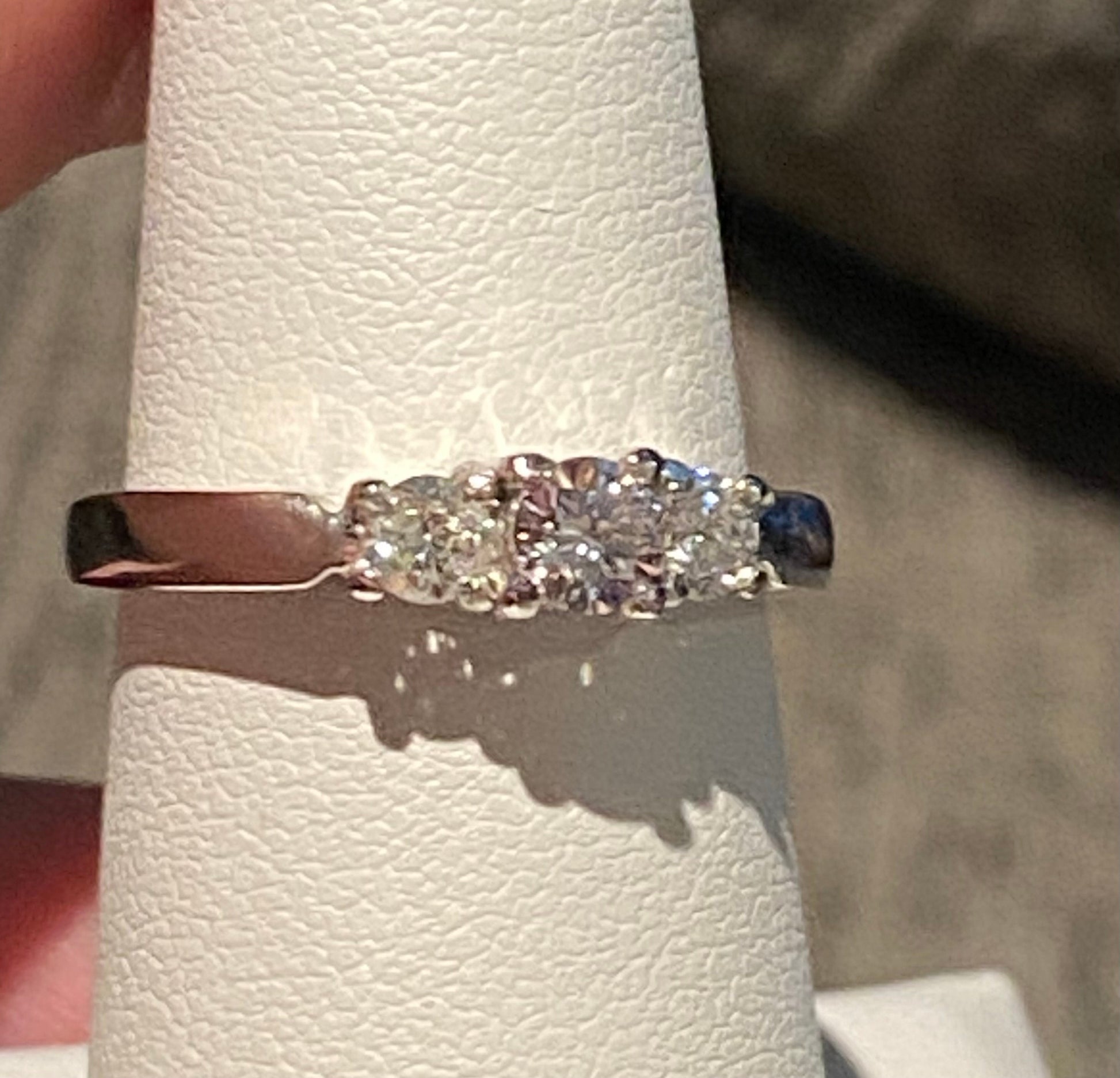 Platinum ring with a very light pink diamond and two white diamonds.