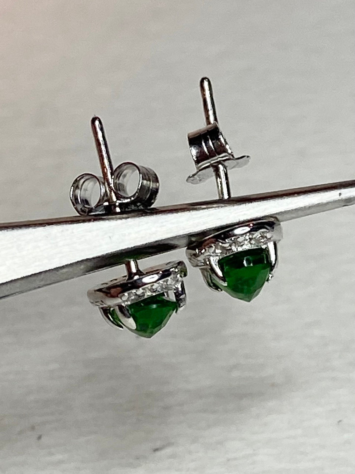 Sterling silver stud earrings with oval chrome diopside and cubic zirconia accents.
