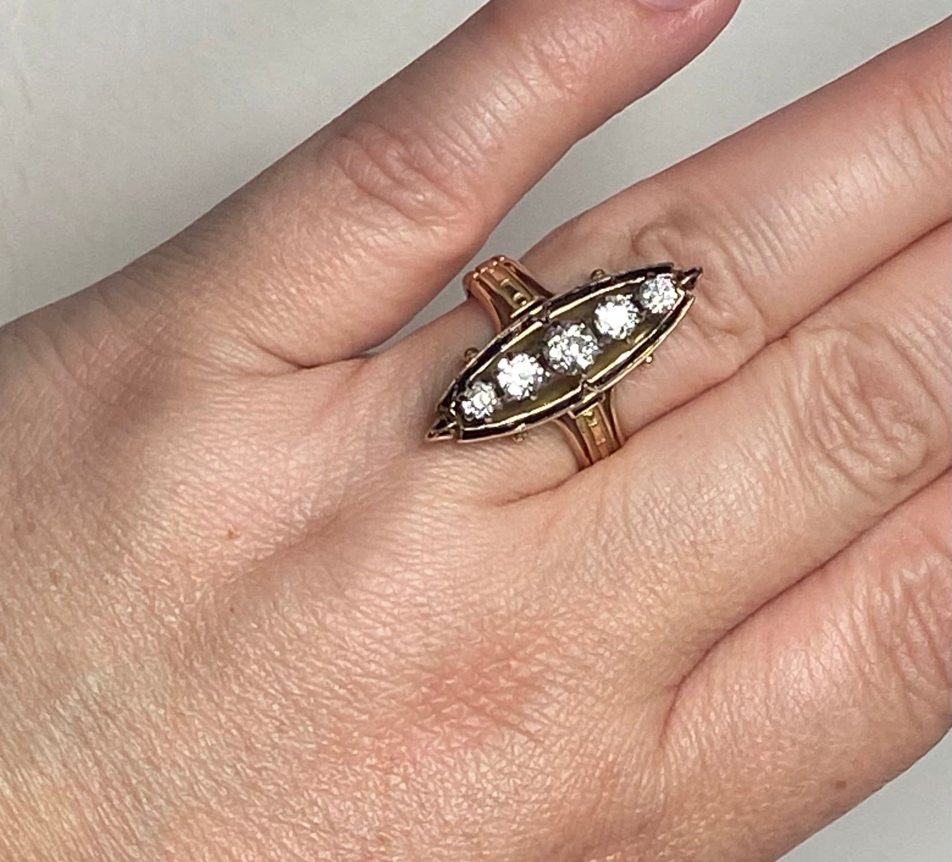 Antique Victorian navette ring with five old mine cut diamonds and black enamel.