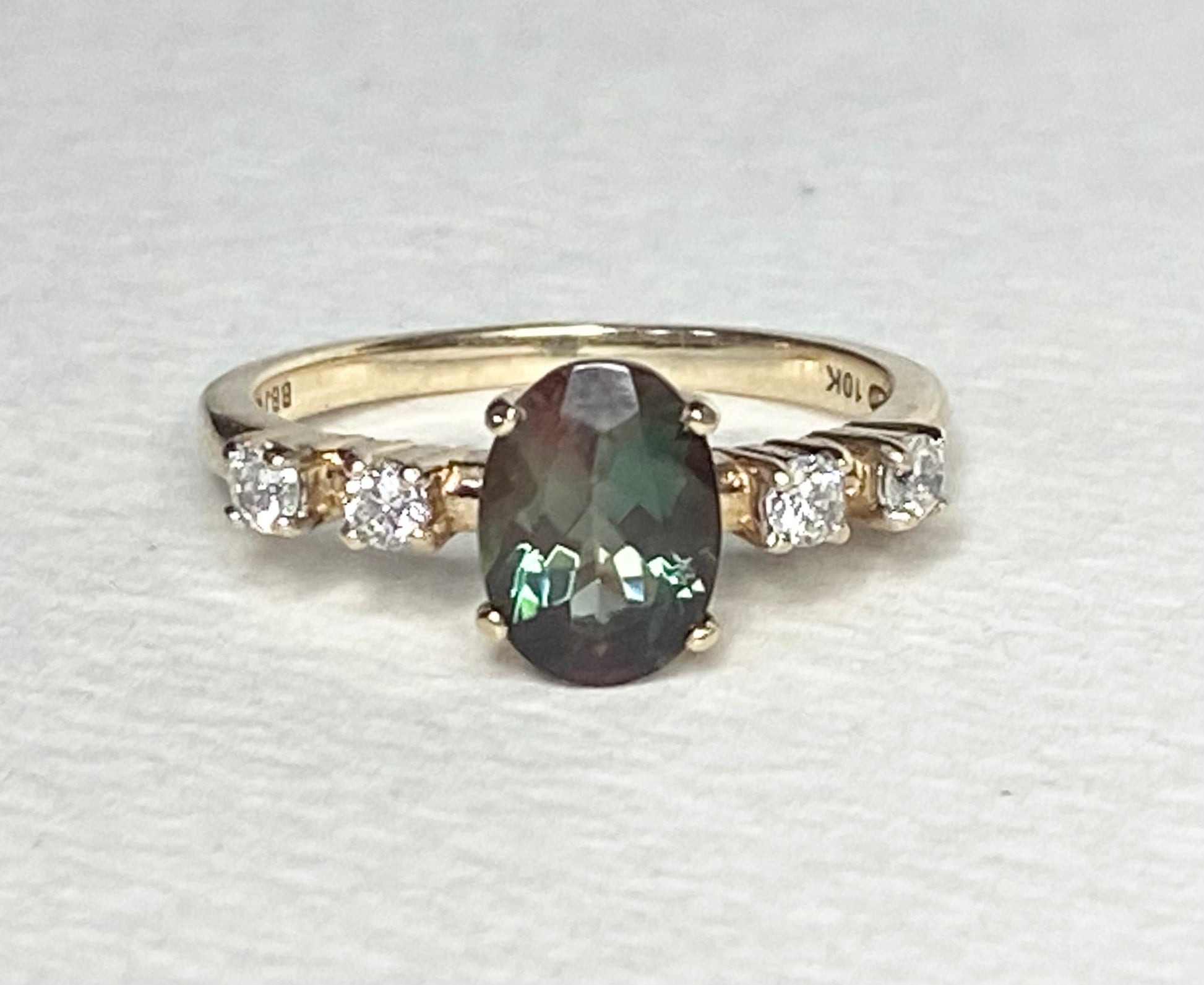 10k yellow gold ring with oval green Oregon sunstone and four diamonds.