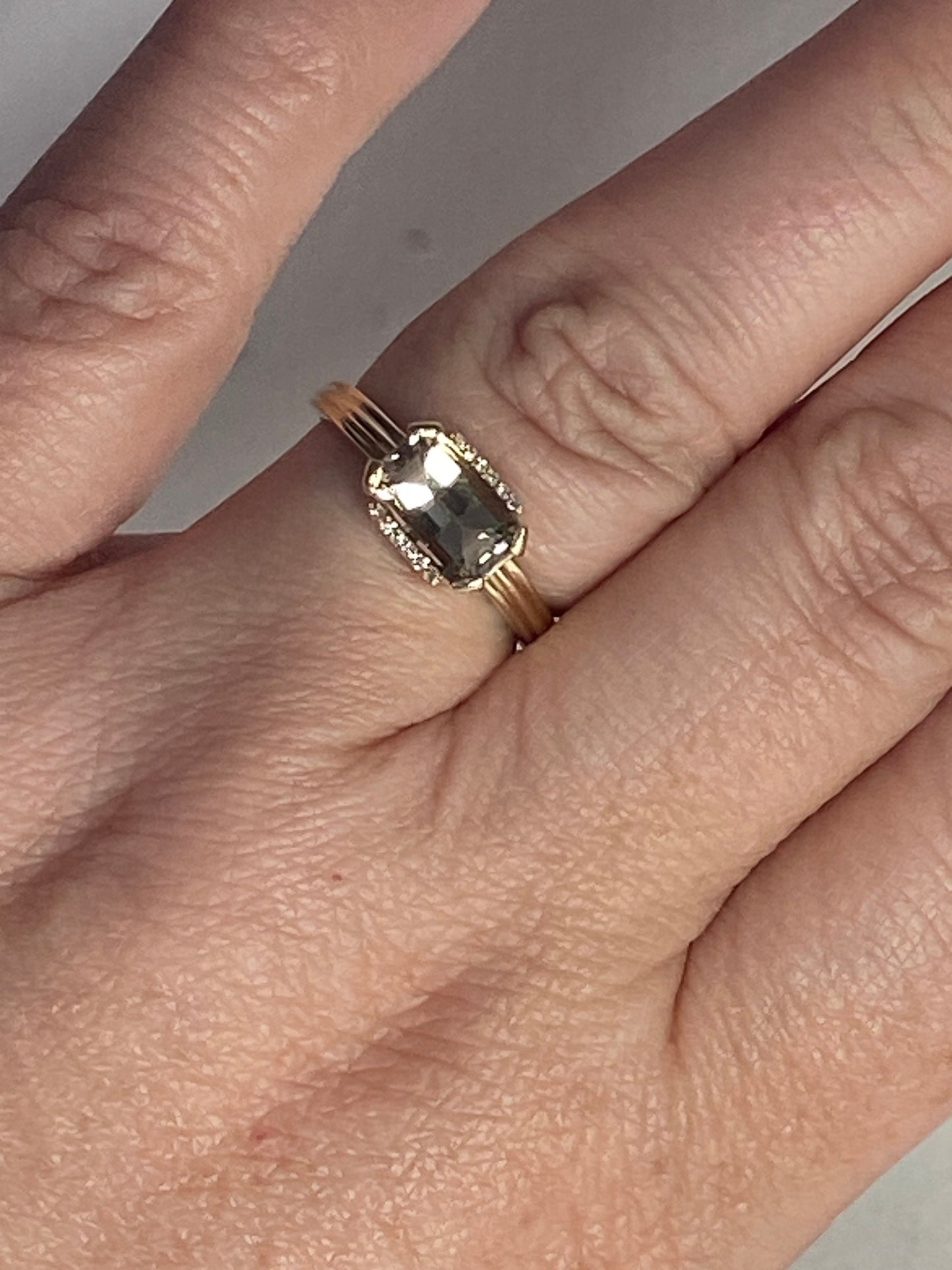 A light green Oregon Sunstone and diamond ring in 10k yellow gold.