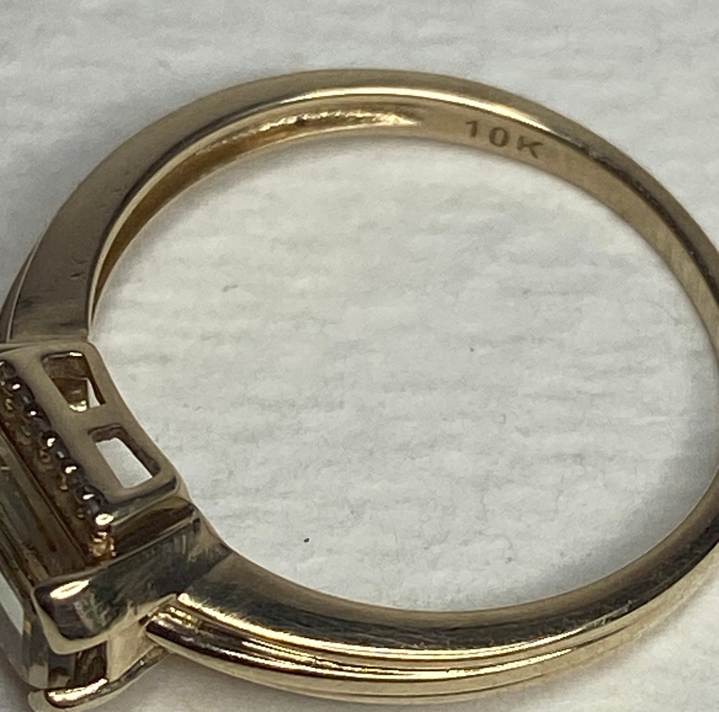 A 10k yellow gold ring with a light green sunstone and diamonds.