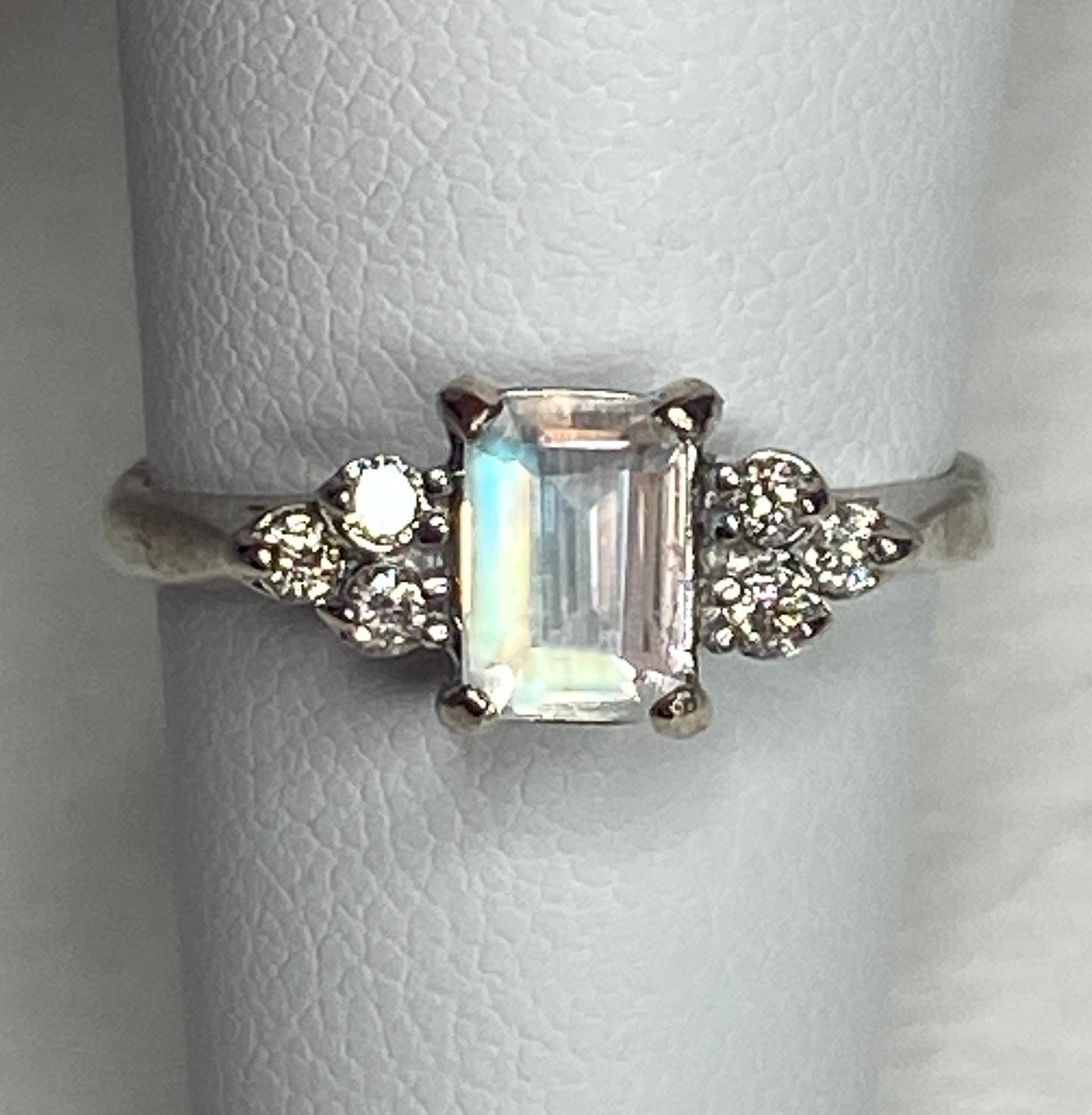 Emerald cut rainbow moonstone ring with diamonds in 14k white gold.