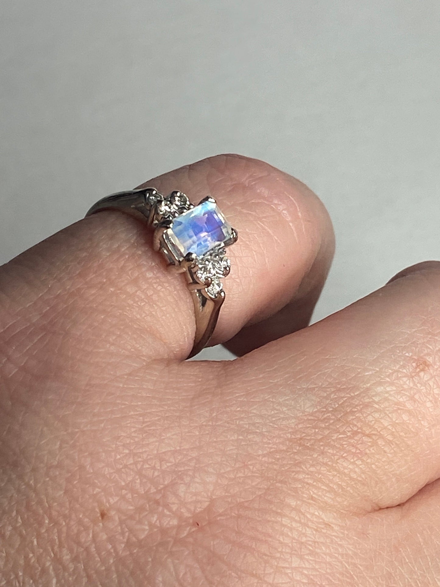 Fine 14k white gold ring with emerald-cut rainbow moonstone and diamonds.