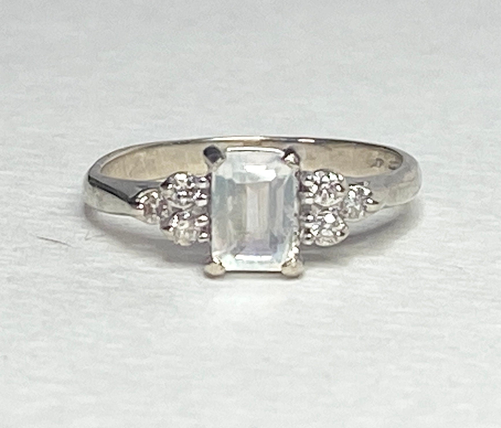 14k white gold ring with emerald-cut rainbow moonstone and diamonds.