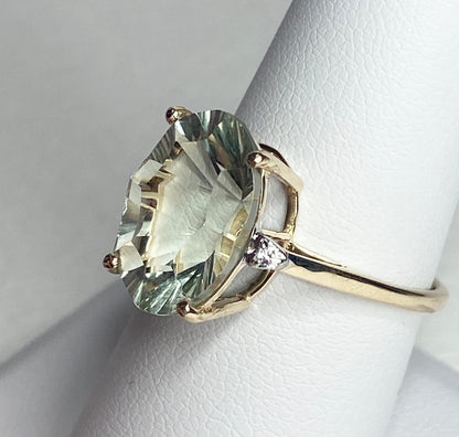 A 9k yellow gold ring with a large oval prasiolite quartz and two zircons.