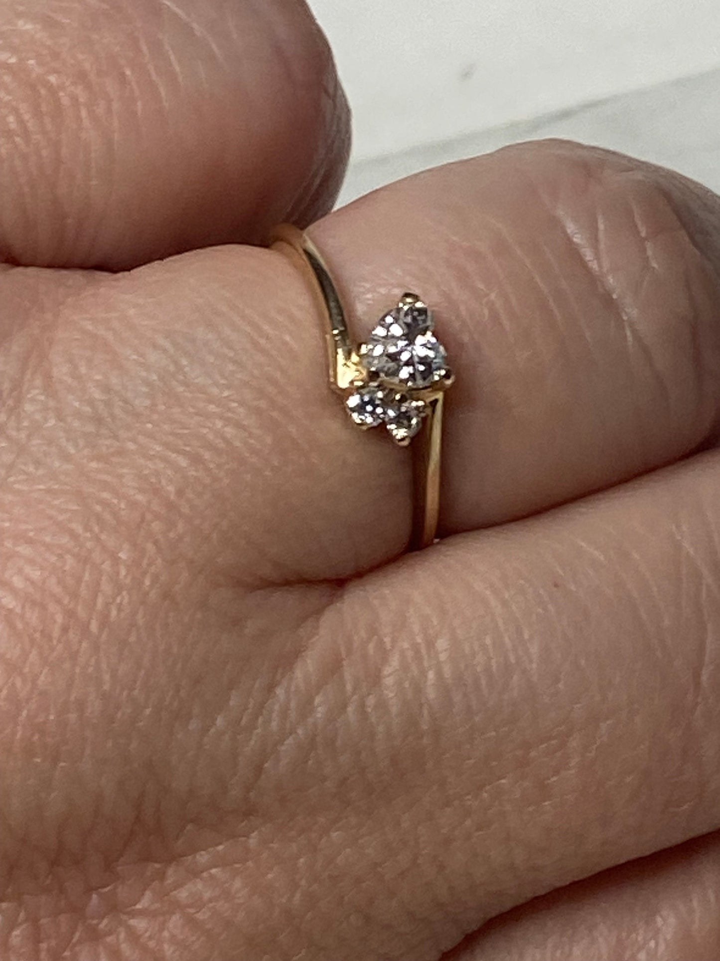 A delicate 14k gold ring with a cluster of three diamonds.