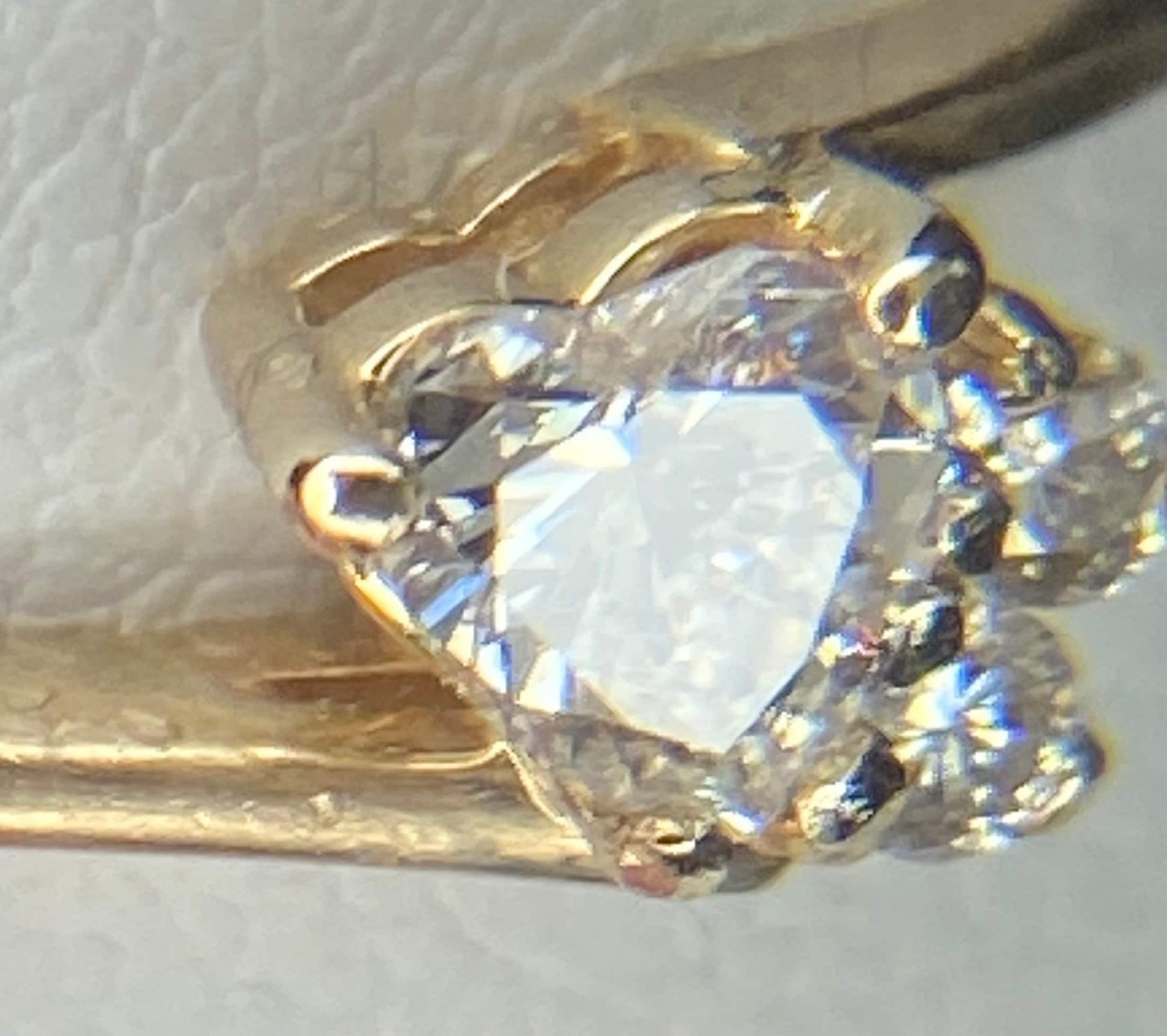 A 14k gold ring with a heart-shaped diamond and two accent diamonds.