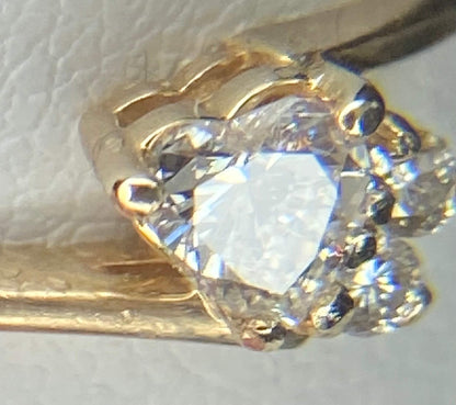 A 14k gold ring with a heart-shaped diamond and two accent diamonds.