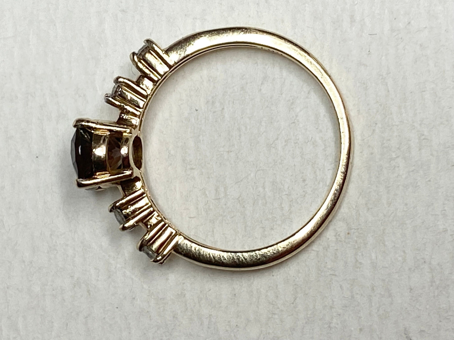 Gold ring with a green sunstone and diamonds.