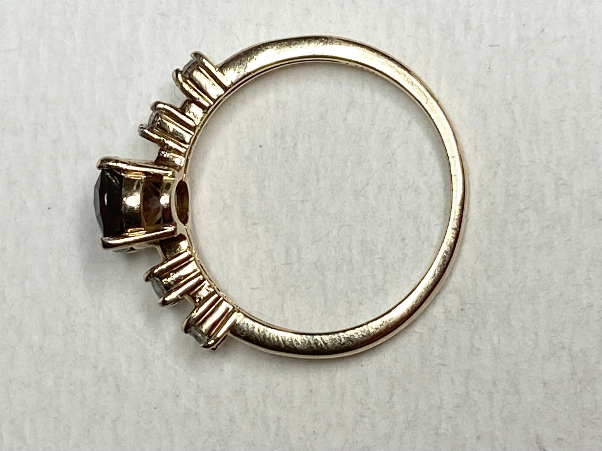 Gold ring with a green sunstone and diamonds.