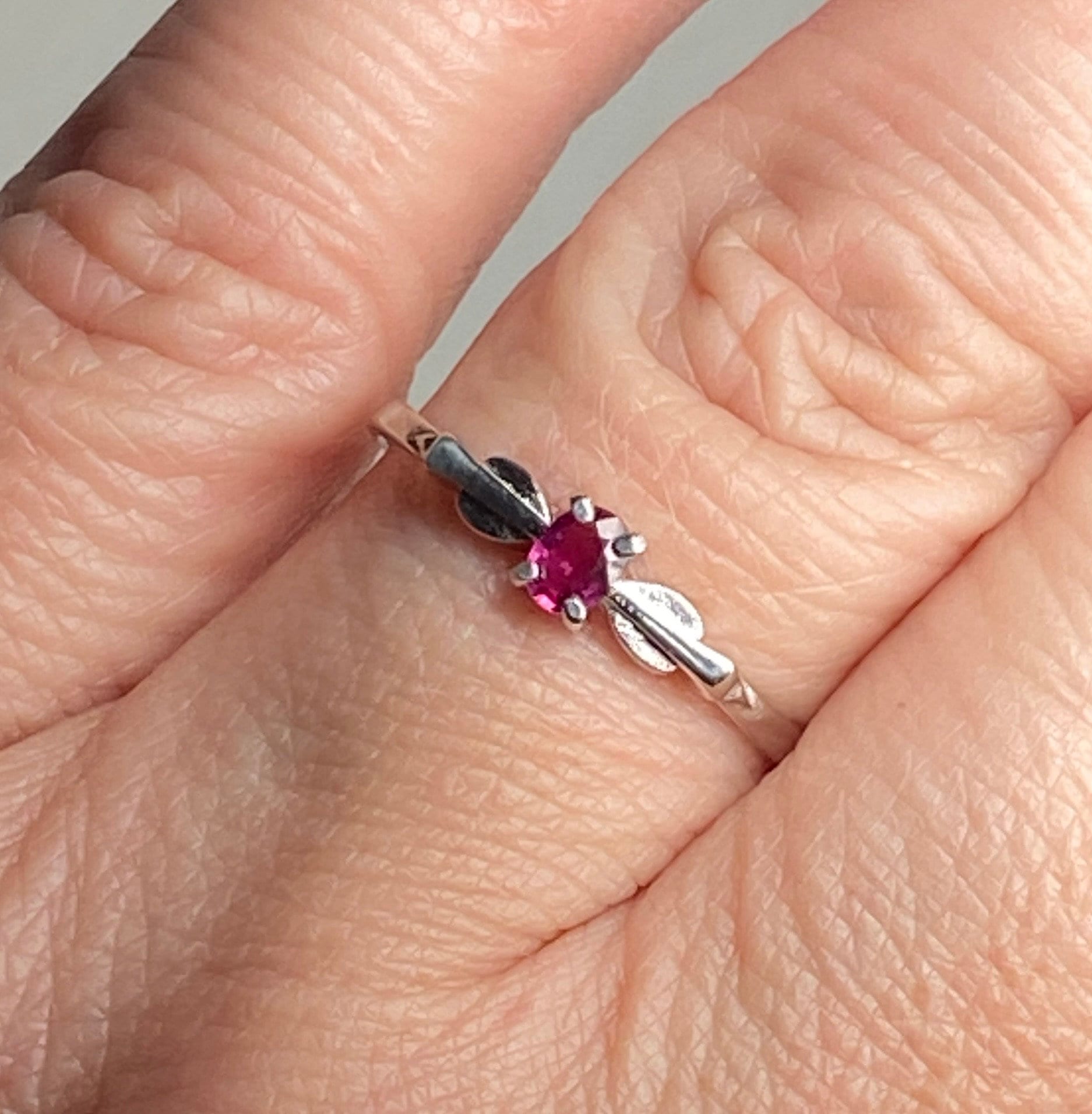 Sterling silver ring with a petite oval Burmese ruby in a spade arrowhead design.