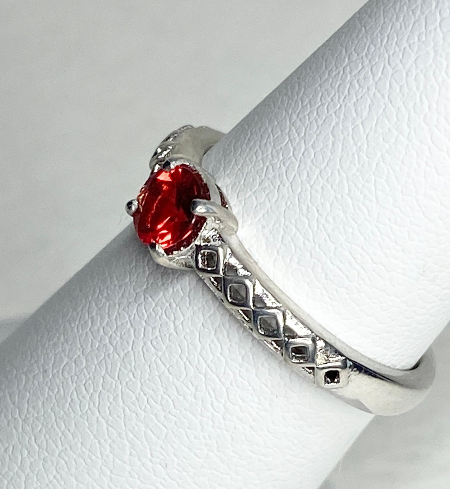 Sterling silver ring with a red sunstone and diamond trellis design.