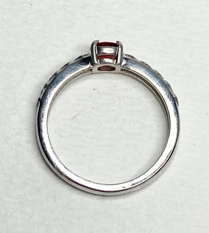 Sterling silver ring with a light red Oregon sunstone and diamond trellis design.