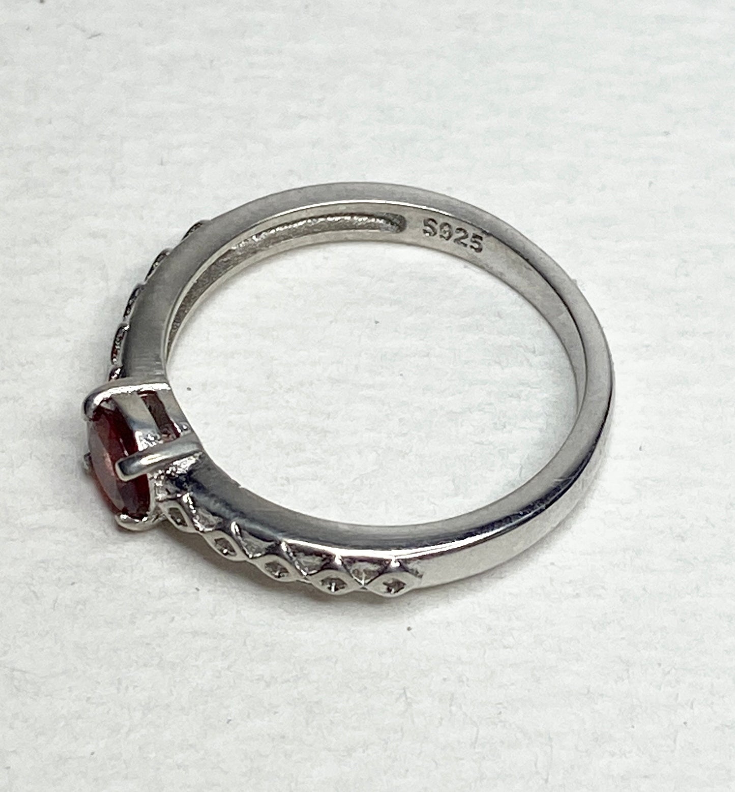 Sterling silver ring with a light red sunstone and diamond trellis design.