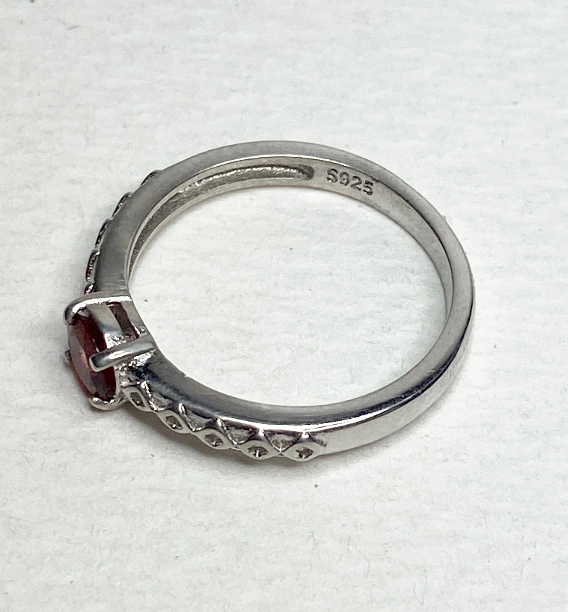 Sterling silver ring with a light red sunstone and diamond trellis design.