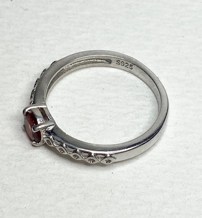 Sterling silver ring with a light red sunstone and diamond trellis design.