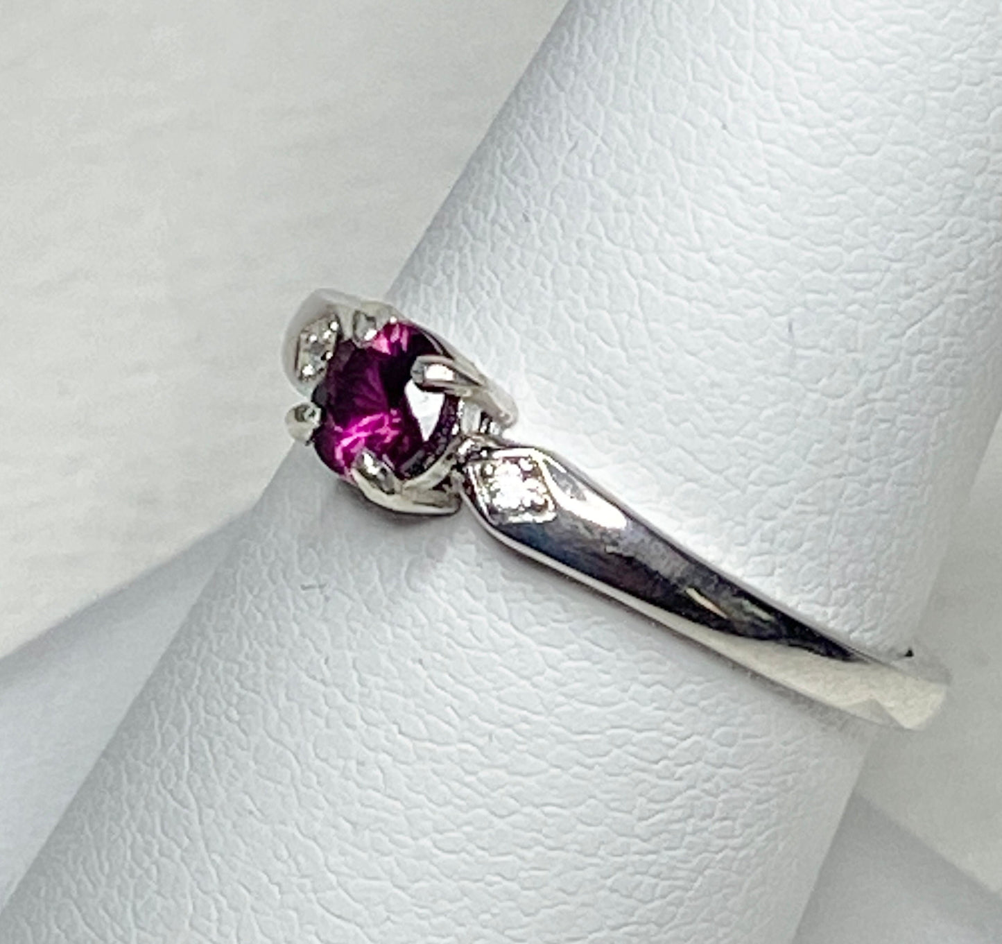 Sterling silver band ring with a purple rhodolite garnet and two small crystals.