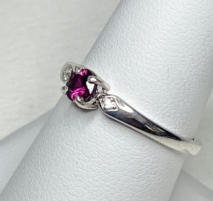 Sterling silver band ring with a purple rhodolite garnet and two small crystals.