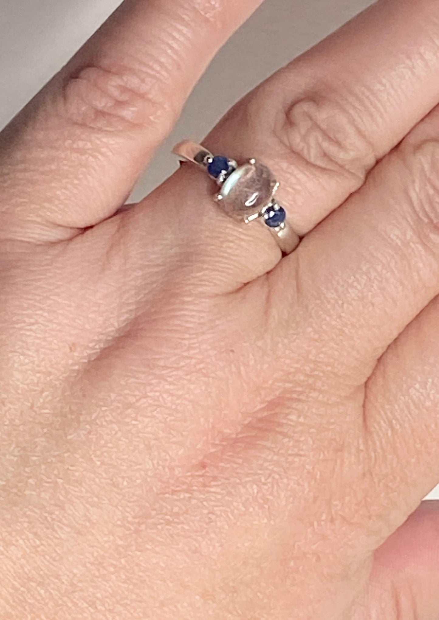 Sterling silver ring with oval labradorite and two blue sapphires.