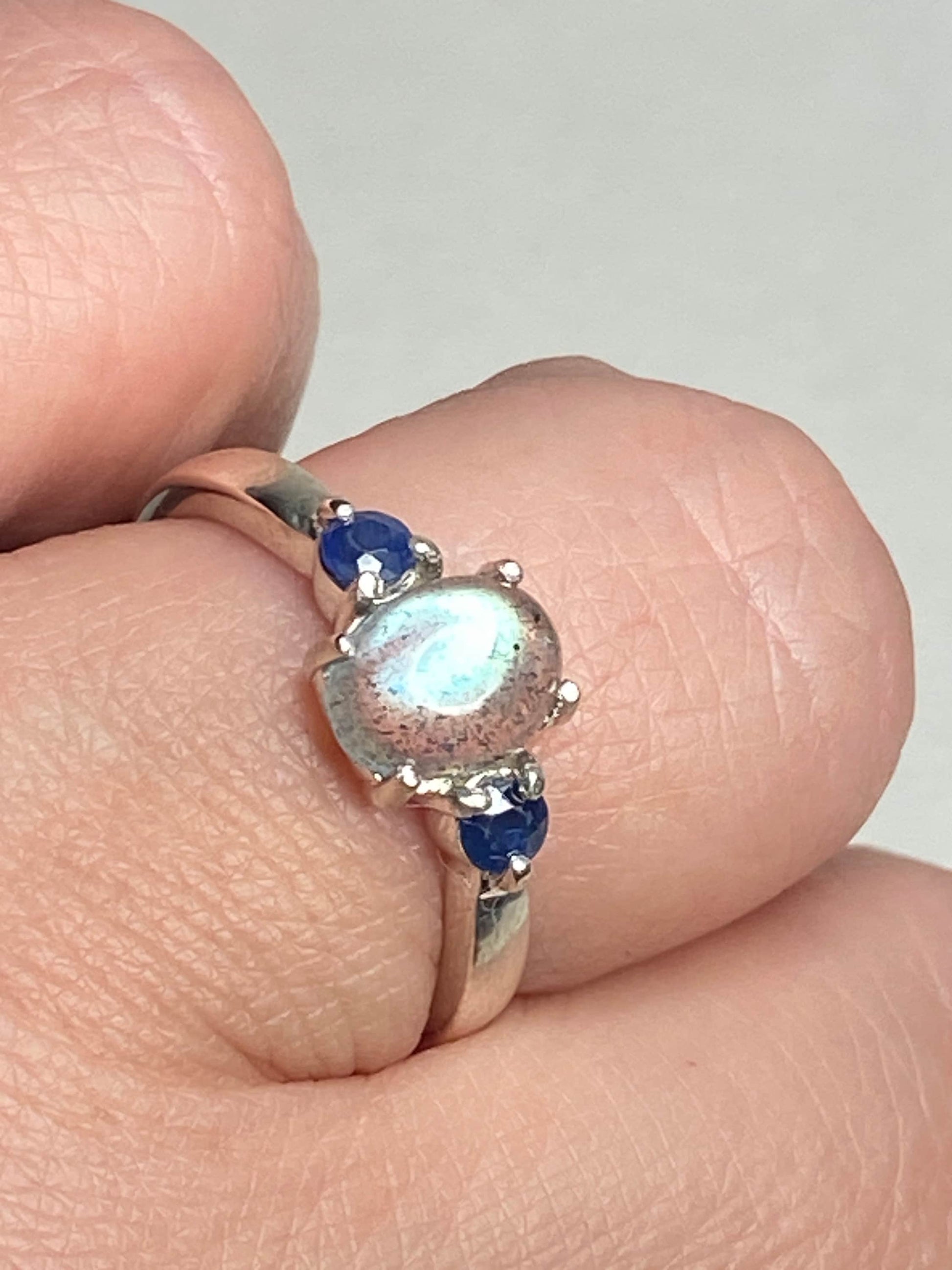 Sterling silver ring with oval labradorite and two round blue sapphires.