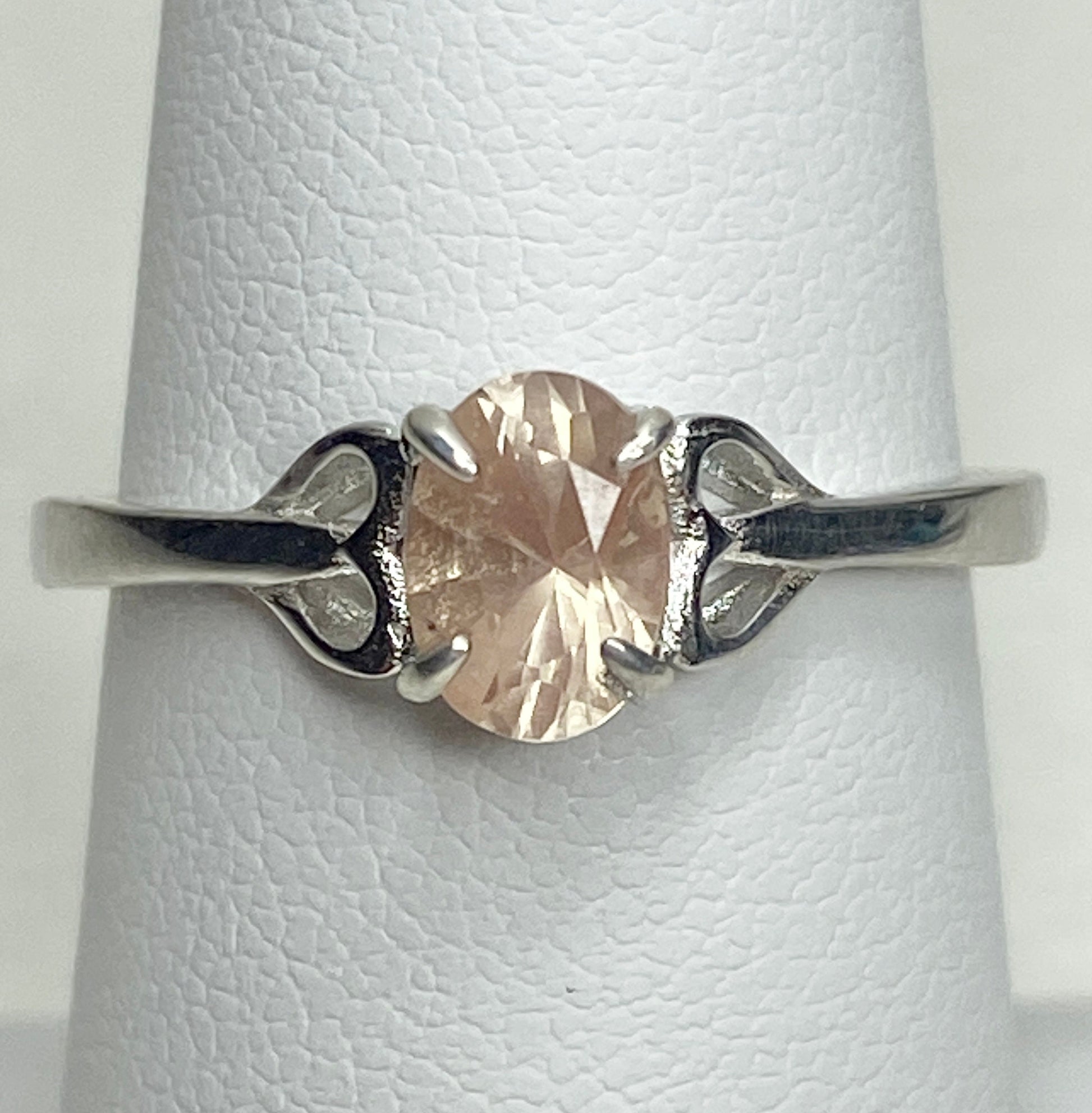 Sterling silver ring with a light peach oval Oregon sunstone and heart-shaped accents.