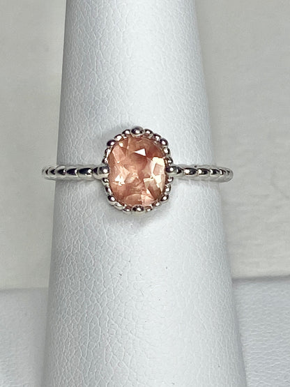 Sterling silver ring with a peach oval Oregon Sunstone in a beaded setting.