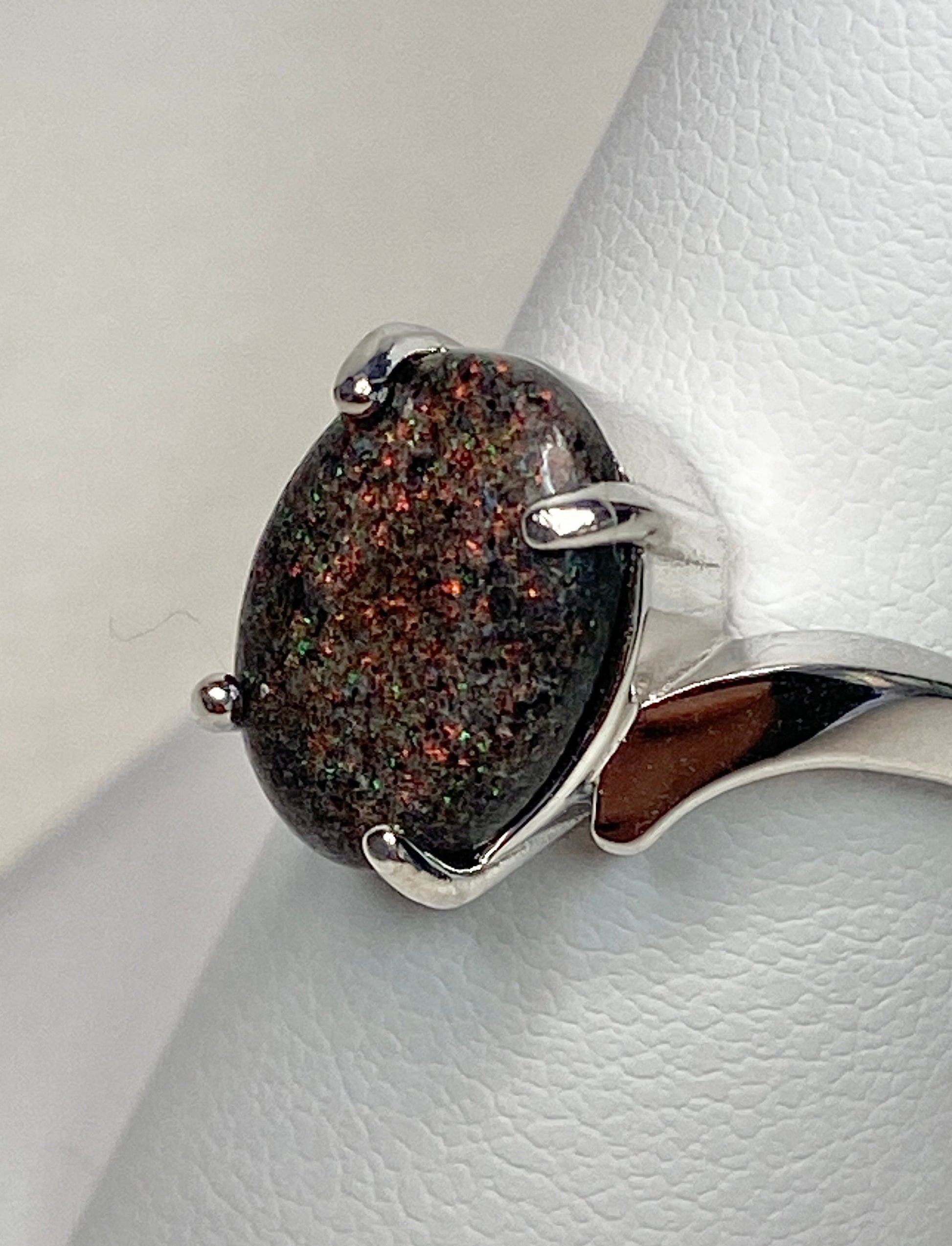 Sterling silver ring with an oval pinfire boulder opal cabochon.