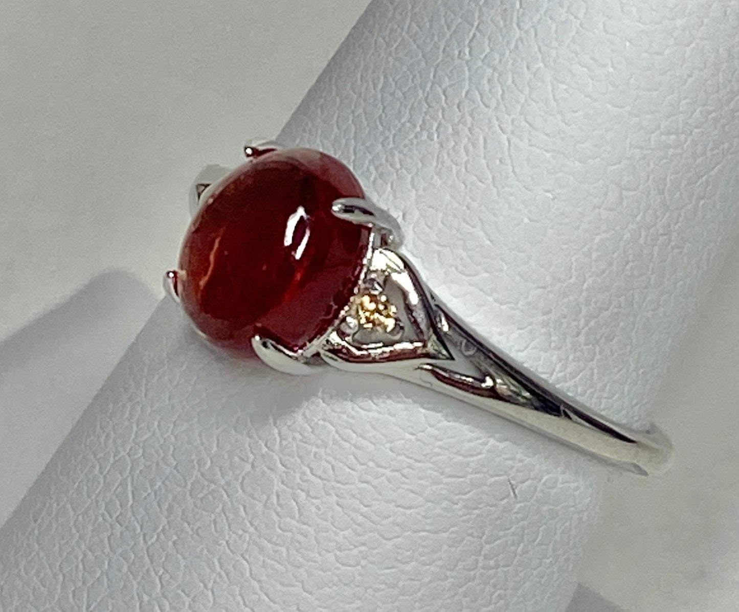 Sterling silver ring with a red Oregon sunstone and natural diamonds.