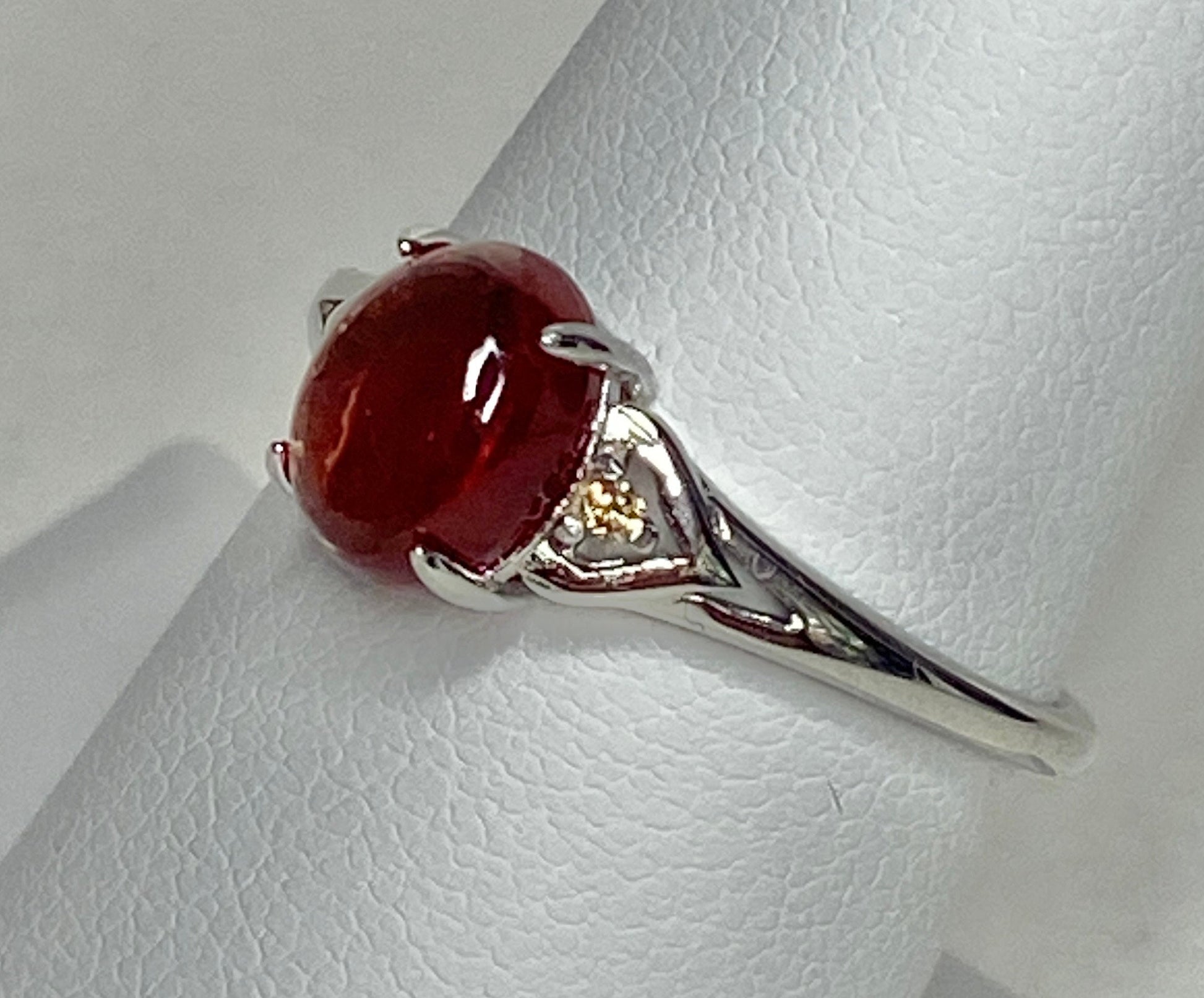 Sterling silver ring with a red Oregon sunstone and natural diamonds.