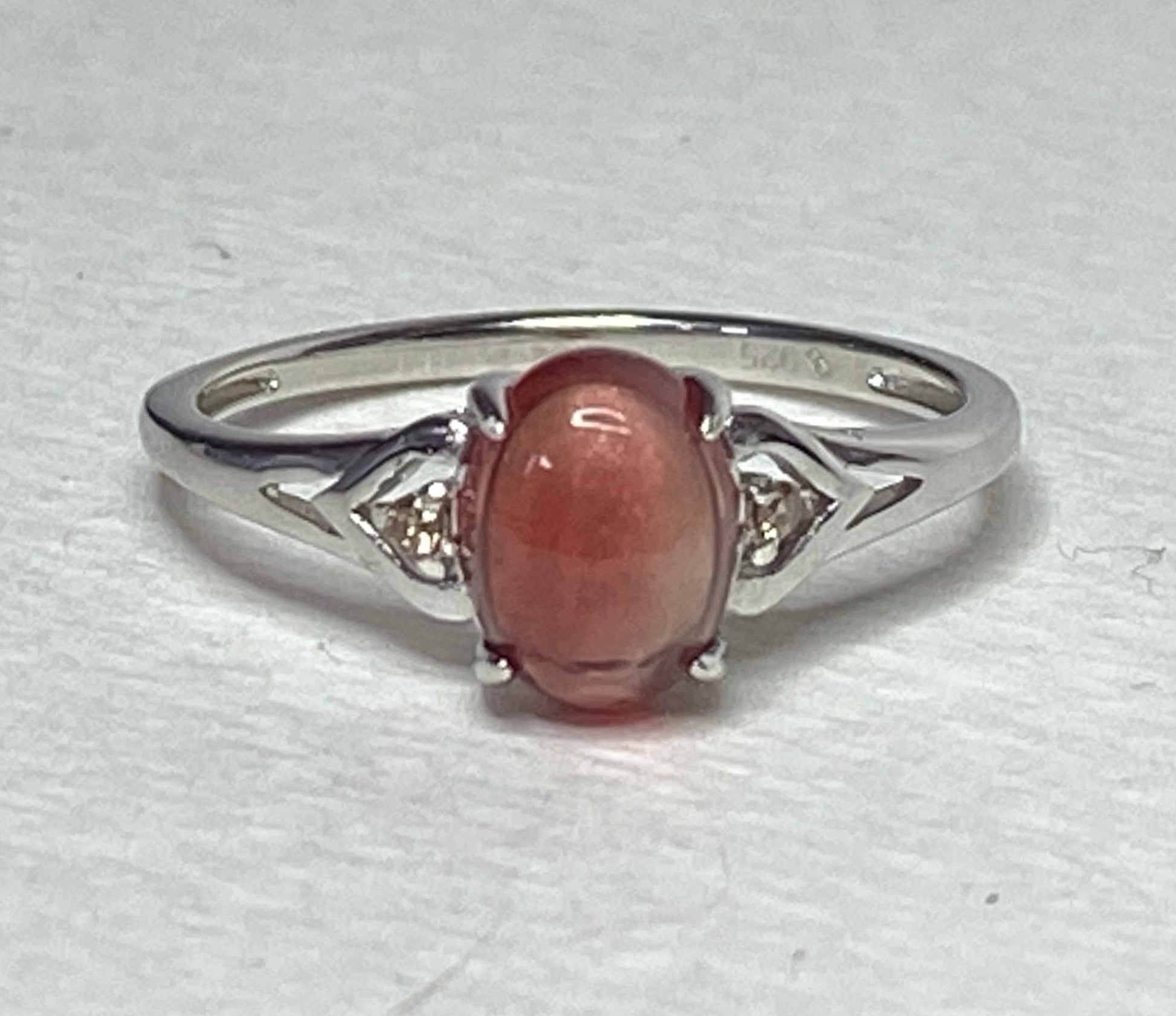 Sterling silver ring with oval red sunstone and small diamonds.