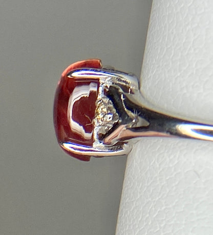 Sterling silver ring with a red Oregon sunstone and natural diamonds.