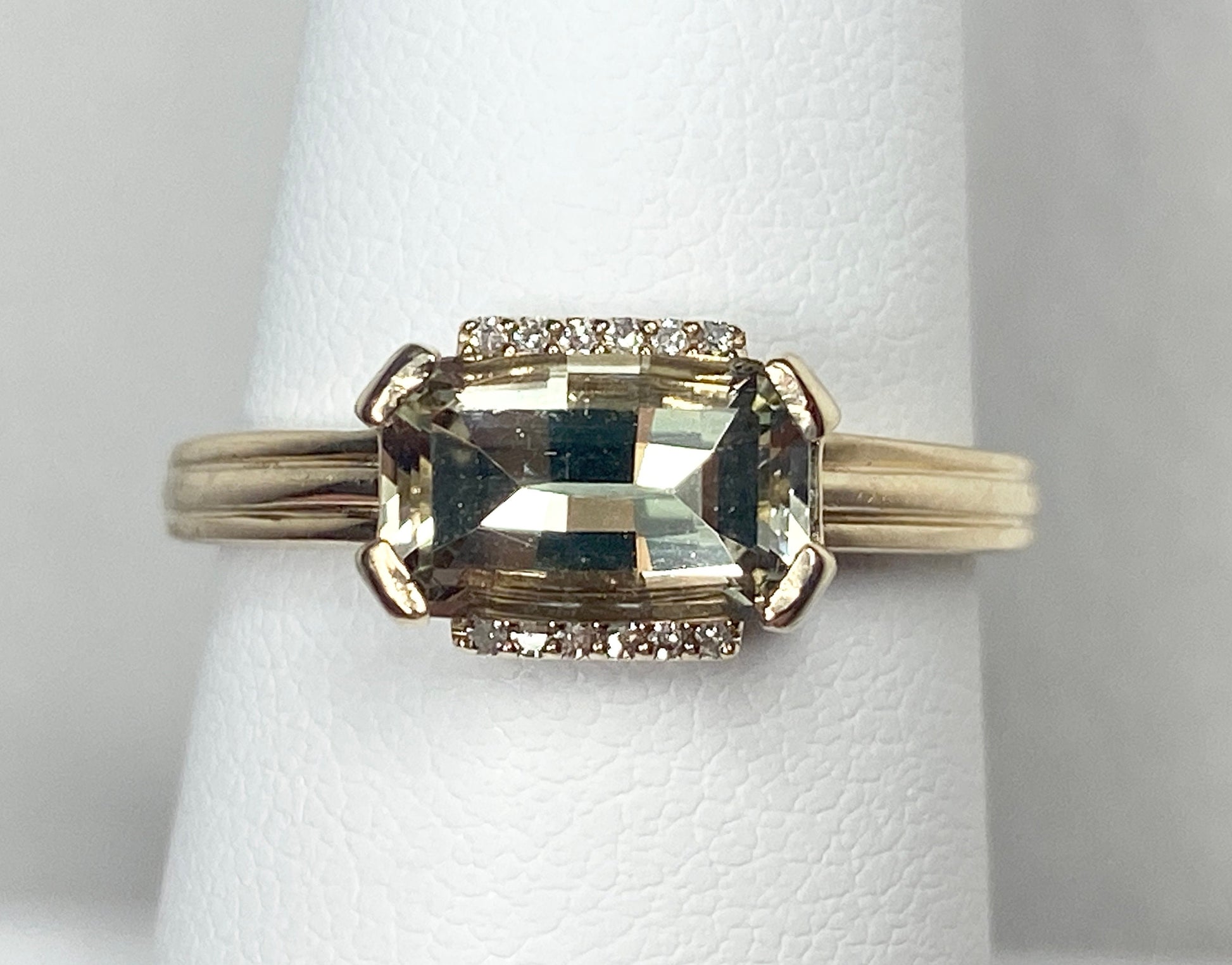 A 10k yellow gold ring with a light green fancy cut Oregon Sunstone and diamonds.