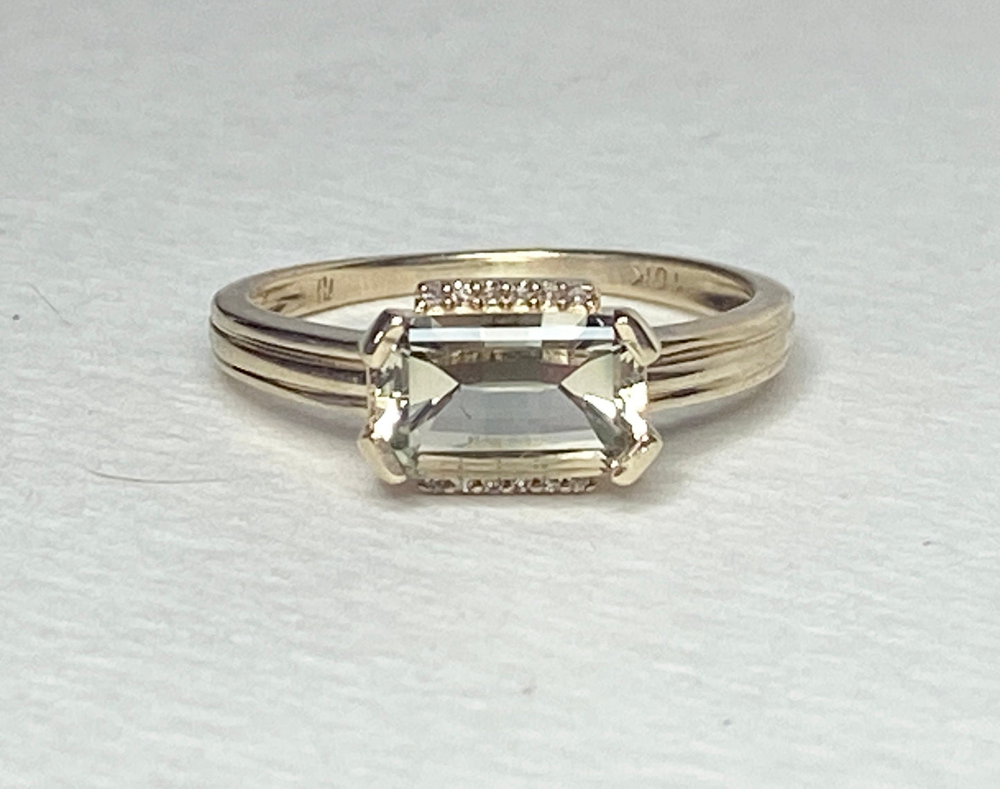 A 10k yellow gold ring with a light green Oregon Sunstone and diamonds.
