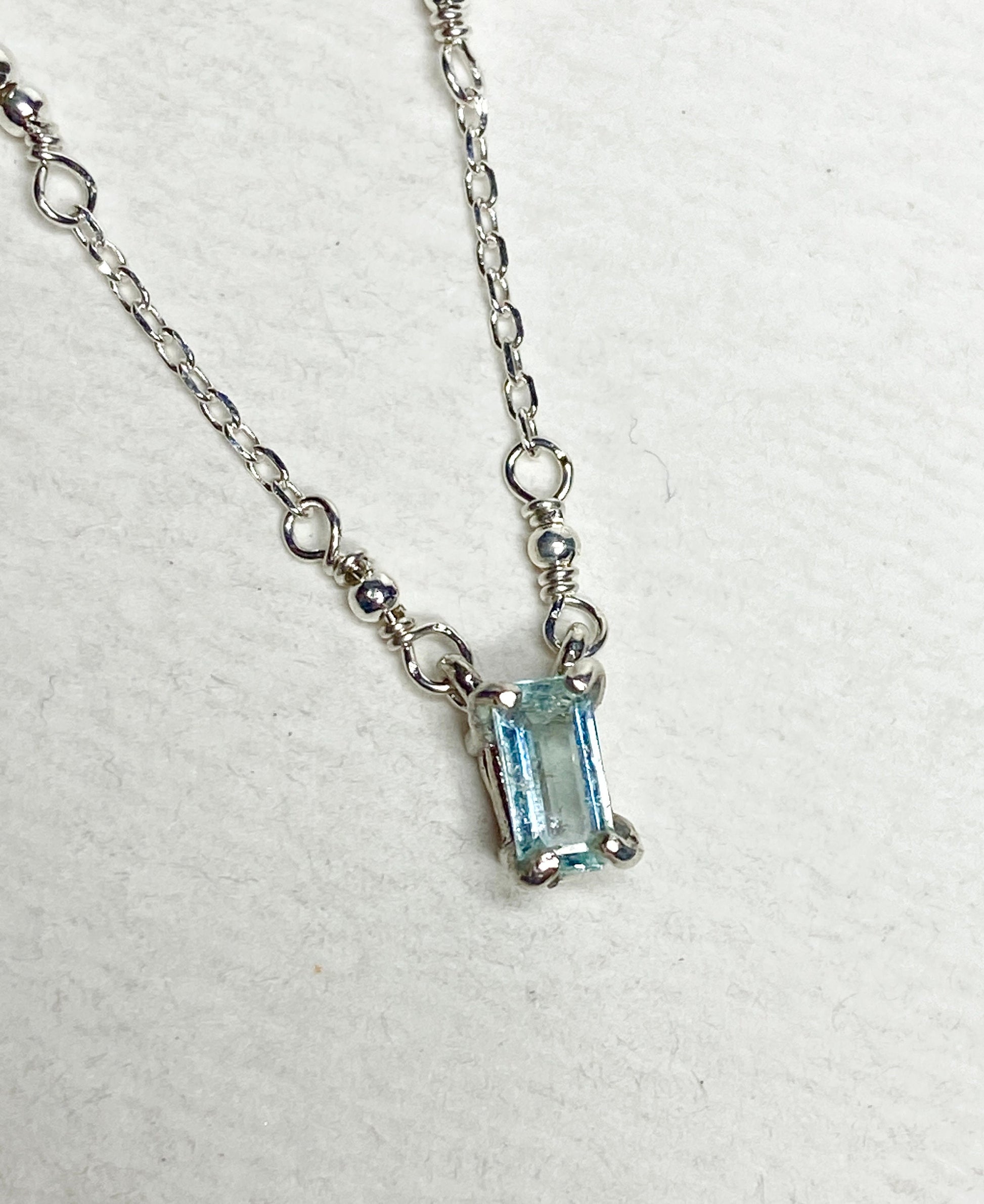 Sterling silver necklace with an emerald-cut cuprian tourmaline pendant.