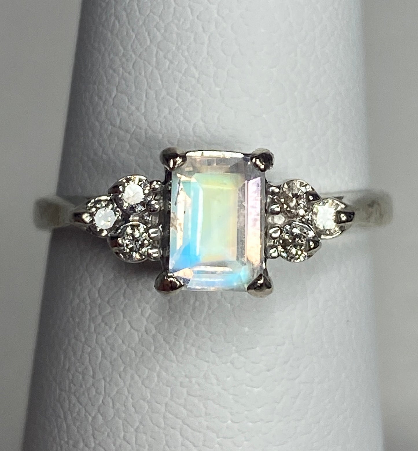 Emerald cut rainbow moonstone ring with diamonds in 14k white gold.