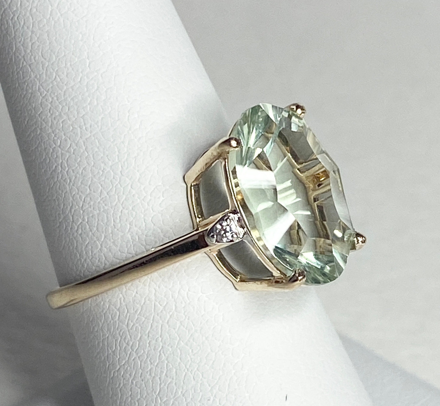 A 9k yellow gold ring with a large oval prasiolite quartz and two zircons.