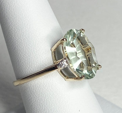 A 9k yellow gold ring with a large oval prasiolite quartz and two zircons.