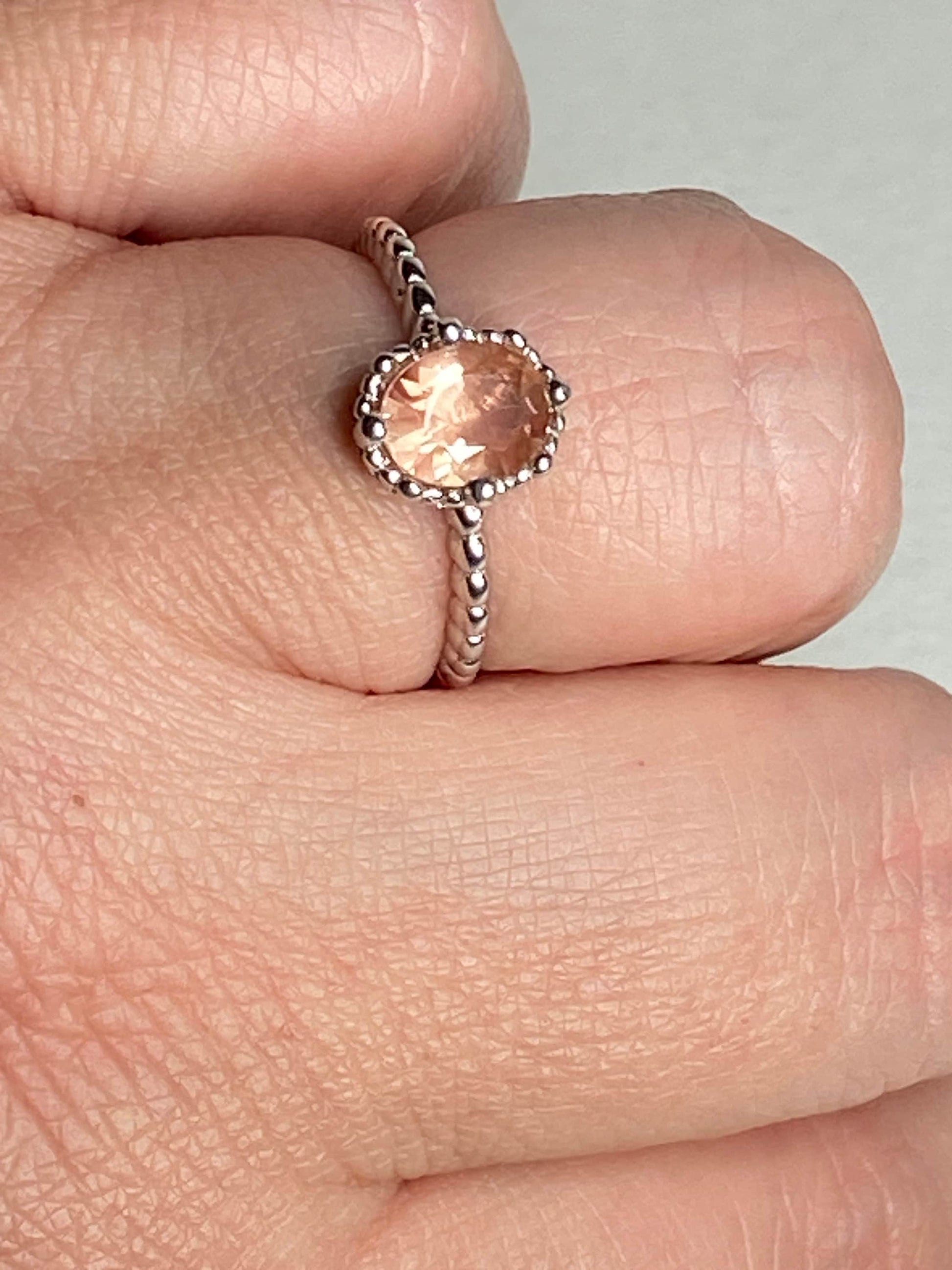 Sterling silver ring with a peach oval Oregon sunstone and beaded band.