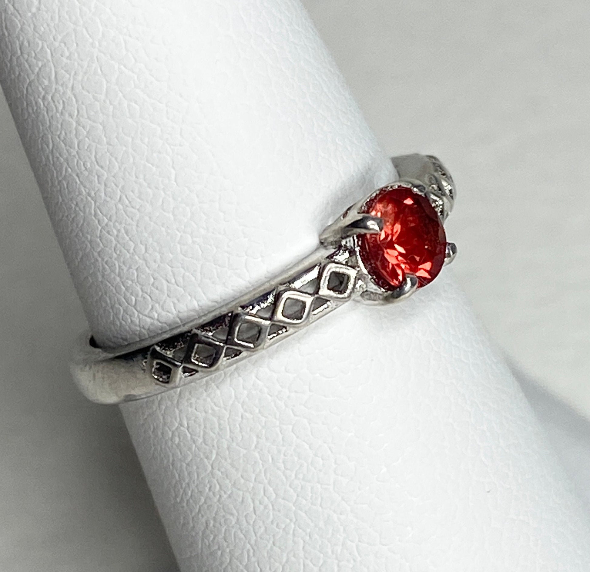 Sterling silver ring with a light red Oregon sunstone and diamond trellis design.