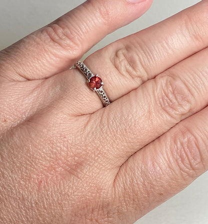 Sterling silver ring with a light red Oregon sunstone and diamond trellis design.