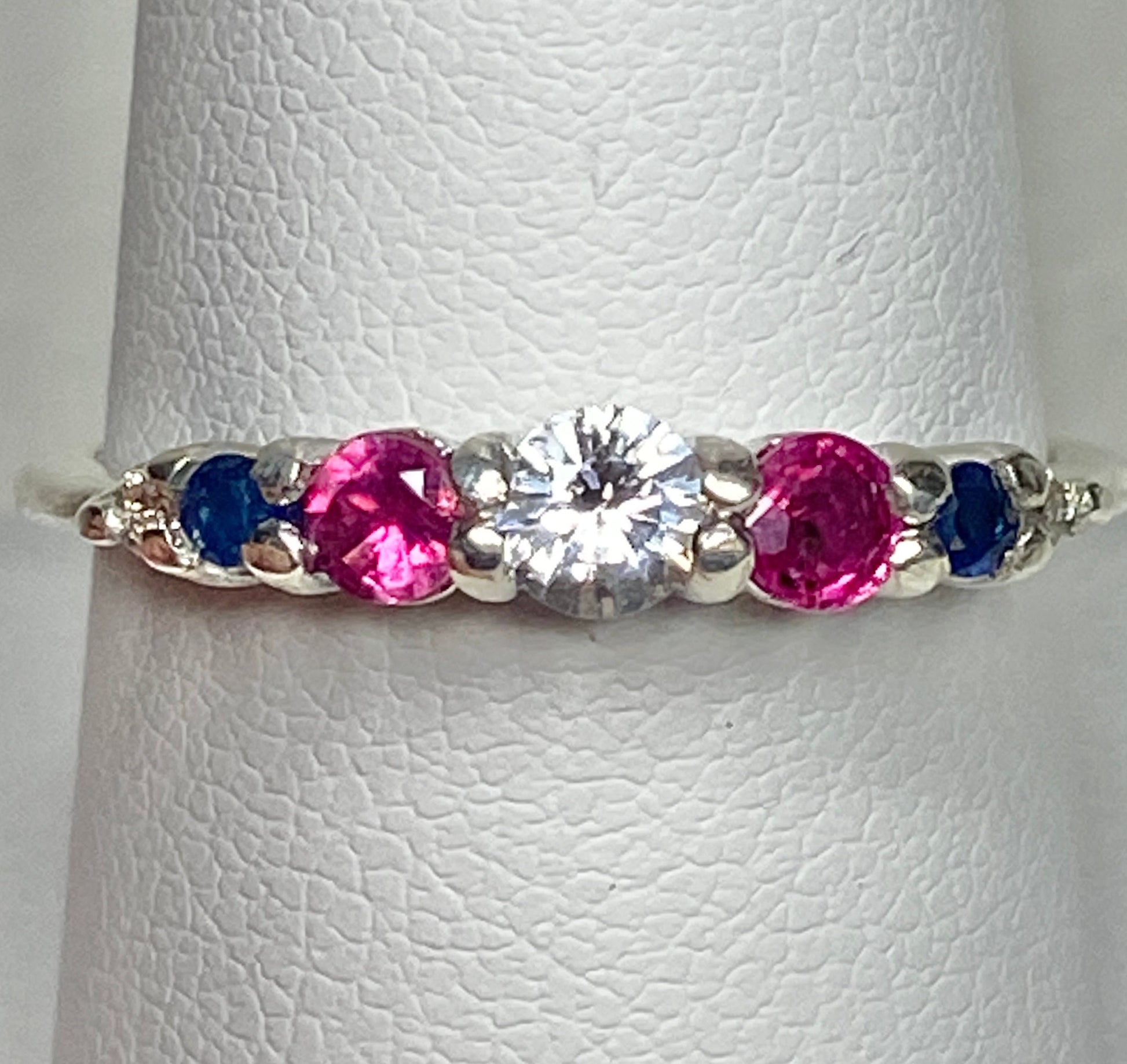 Sterling silver ring with a white sapphire, rubies, diamonds, and sapphires.